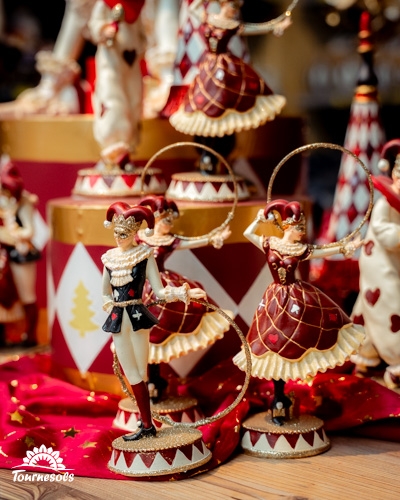 Figurines de Noël élégantes avec motifs arlequin sur fond festif.